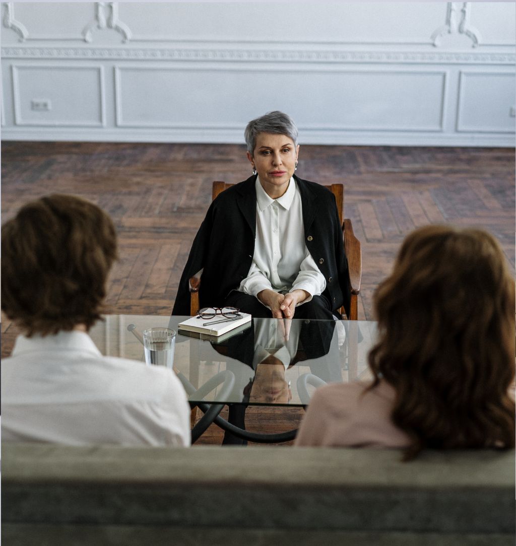 Man in Black Suit Standing Beside Woman in White Dress Shirt